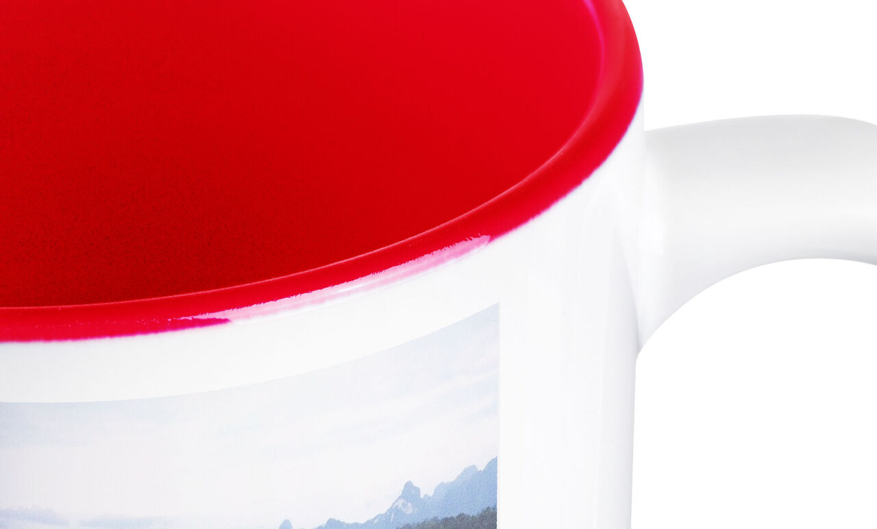 Intérieur rouge d'une tasse avec motif de montagne à l'extérieur